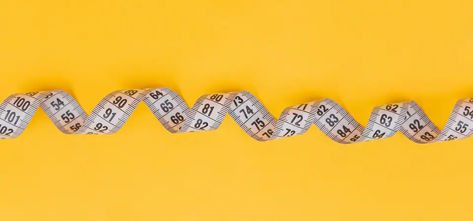 White measuring tape on a yellow background